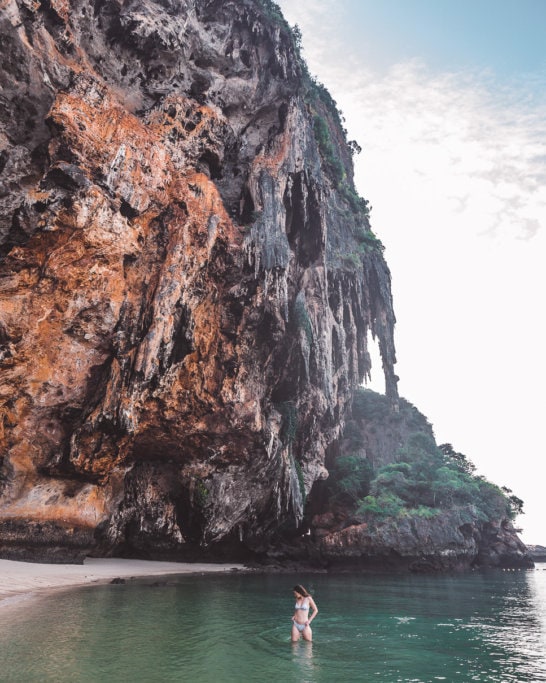 Sindhya stands in water in front of Phra Nang Cave. Fun and active things to do in Krabi
